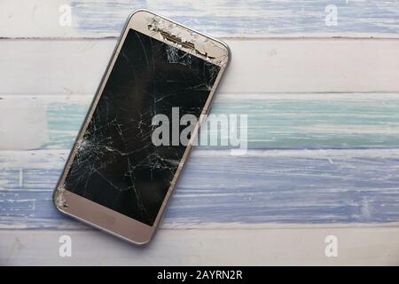 vista dall'alto dello smartphone rotto sul tavolo Foto Stock