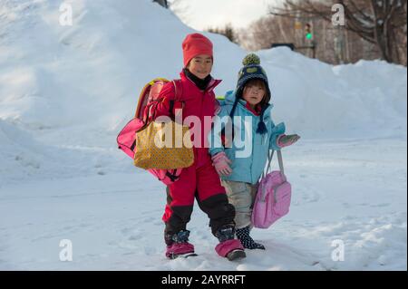 Scena di strada con i bambini della scuola locale in Ainu Kotan, che è un piccolo villaggio di Ainu in Akankohan, parco nazionale di Akan, Hokkaido, Giappone. Foto Stock