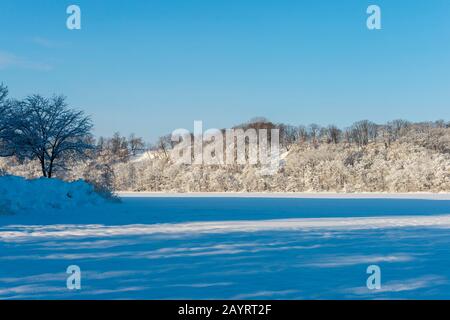 Vista del lago ghiacciato Abashiriko e foresta coperta di neve vicino Abashiri, una città sull'isola di Hokkaido, Giappone. Foto Stock