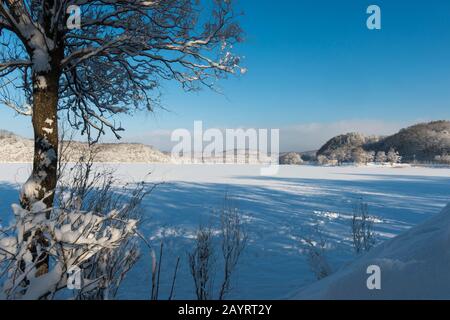 Vista del lago ghiacciato Abashiriko e foresta coperta di neve vicino Abashiri, una città sull'isola di Hokkaido, Giappone. Foto Stock