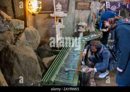 Persone nella grotta dello Zeniarai Benzaiten Ugafuku Santuario, popolarmente conosciuto semplicemente come Zeniarai Benten, un santuario Shinto a Kamakura, Kanagawa prefectu Foto Stock