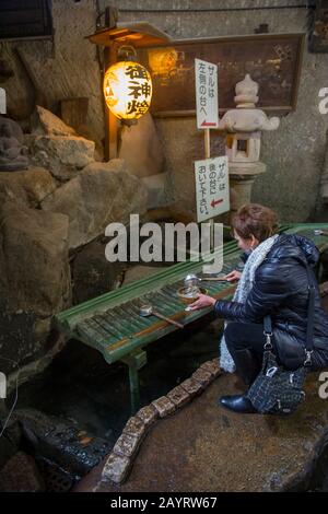 Tourist (Model Release 20020923-10) nella grotta del Santuario Zeniarai Benzaiten Ugafuku, popolarmente conosciuto semplicemente come Zeniarai Benten, un santuario Shinto i Foto Stock