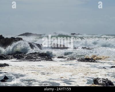 Wild Rough Seas, Oceano Pacifico, dopo la pioggia, onde che si infrangono contro e sopra le rocce, mare spray volare, acqua schiumosa, Sawtell NSW Australia Foto Stock
