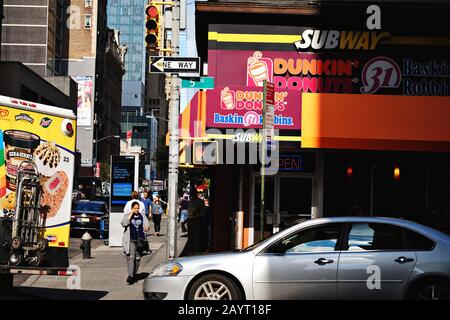 Midtown Manhattan, New York City, un'audace scena di strade multicolore di marchi famosi in tutto il mondo all'angolo della 5th Avenue Foto Stock