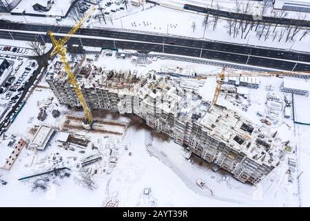 costruzione di un edificio residenziale a più piani in inverno. vista aerea dal drone volante Foto Stock