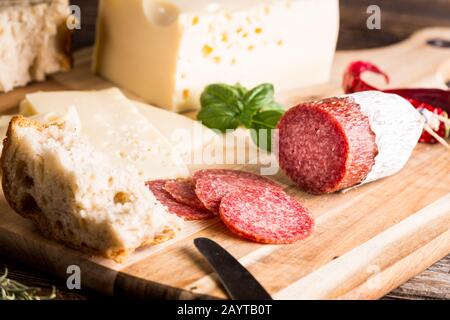 Salame secco o salsiccia con formaggio, pane ed erbe. Foto Stock