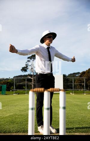 Cricket umpire facendo segni in piedi su un campo di cricket Foto Stock