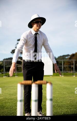 Cricket umpire facendo segni in piedi su un campo di cricket Foto Stock