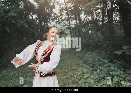 Una donna in abiti tradizionali turcici orientali ricamati esegue una danza nazionale nel Parco Foto Stock