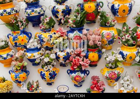 Ceramiche colorate appese su una parete di un negozio di souvenir in una strada stretta a Mijas, un piccolo villaggio sulla Costa del Sol vicino a Malaga in Andalusia, Spa Foto Stock