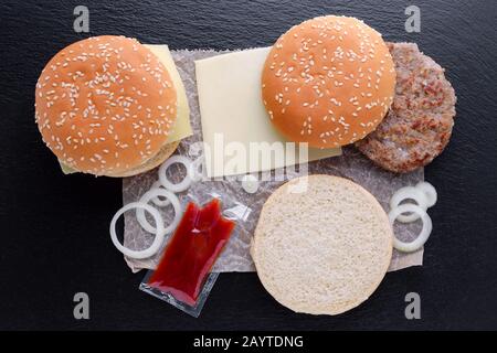 preparazione di hamburger fatti in casa su sfondo nero, piatto Foto Stock