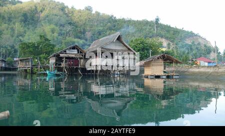 Banay Banay, Davao Oriental, Filippine - marzo 2016: Case su palafitte riflesse nelle acque lagunari di un villaggio di pescatori nella parte meridionale del Th Foto Stock