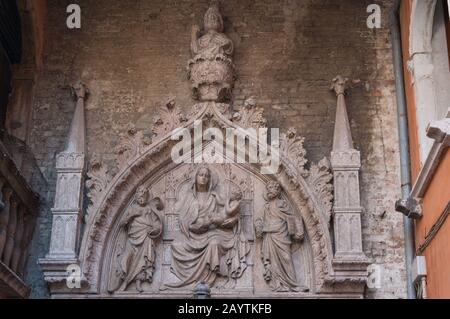 Scultura in pietra di Santa Maria che tiene il bambino Gesù e due apostoli sui suoi lati con la figura di Dio Padre sopra. Chiesa decorazione scena biblica Foto Stock