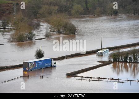 Un camion e un pullman sommersi dall'acqua del fiume Teme sulla A443 nei pressi di Lindridge, Worcestershire, mentre il periodo successivo alla tempesta Dennis porta forti piogge e inondazioni. Foto Stock