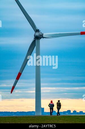 Walker sul mucchio di scorie di Hoheward a Herten, centrale eolica sul mucchio di scorie di Hoppenbruch, vista dello skyline di Essen, NRW, Germania Foto Stock