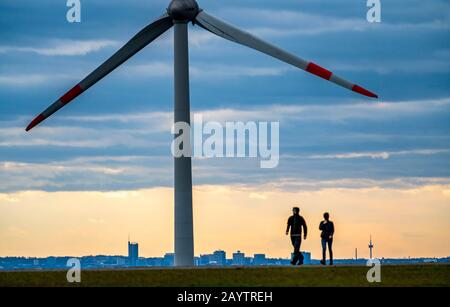 Walker sul mucchio di scorie di Hoheward a Herten, centrale eolica sul mucchio di scorie di Hoppenbruch, vista dello skyline di Essen, NRW, Germania Foto Stock