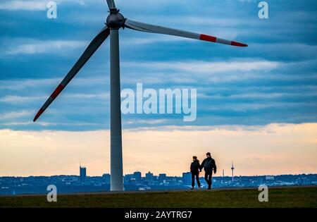 Walker sul mucchio di scorie di Hoheward a Herten, centrale eolica sul mucchio di scorie di Hoppenbruch, vista dello skyline di Essen, NRW, Germania Foto Stock