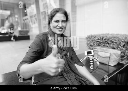 Felice matura bella donna indiana esplorare la città Foto Stock