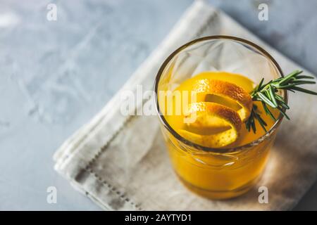 Bicchiere di cocktail al borbonico al miele con rosmarino sciroppo semplice o bevanda analcolica a base di whisky in casa con decorazione arancio e rosmarino buccia d'arancia Foto Stock