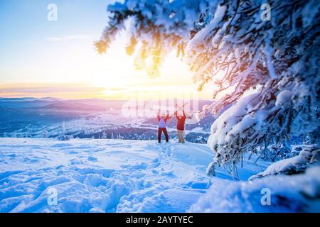 Due amici attivi snowboarder e sciatore in piedi sulla cima della montagna cielo blu alba. Concept stazione sciistica foresta invernale Foto Stock