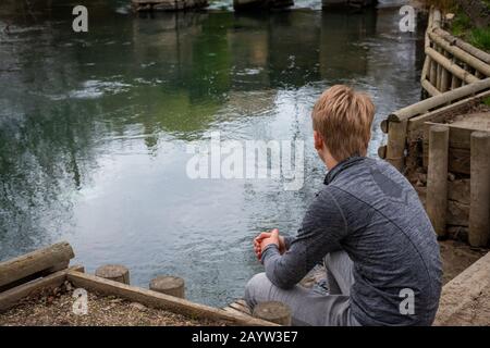 Teenage booquaters sui passi vicino al fiume nella campagna ;Pensare Foto Stock