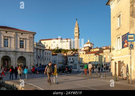 I turisti che camminano a Tartinijev trg (Piazza Tartini) a Pirano, in Slovenia, in un caldo pomeriggio autunnale Foto Stock