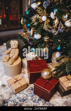 Immagine verticale dell albero di Natale decorato con sfere e molti presenta in abete. Momenti piacevoli e festoso evento. Composizione della pila con Foto Stock