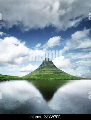 Splendido paesaggio con la montagna di Kirkjufell, il lago limpido e il paesaggio cloudscape nel cielo blu Foto Stock