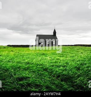 Paesaggio fantastico con la famosa pittoresca chiesa nera di Budir nella regione della penisola di Snaefellsnes in Islanda e campo di erba verde bellezza Foto Stock