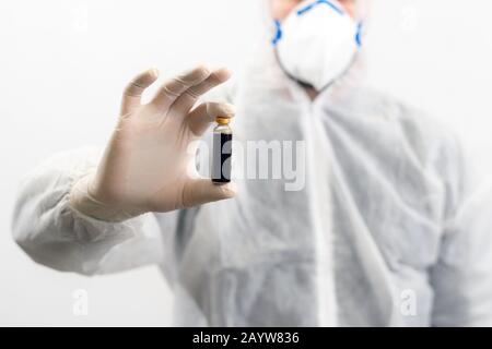 Scienziato con una bottiglia di vaccino per la conservazione della maschera sviluppato per il virus corona. Covid-19 antidoto. Il medico scopre il trattamento per malattia epidemica. Globale Foto Stock