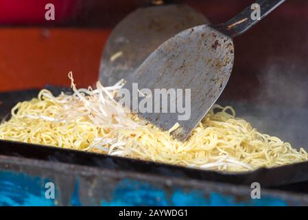 Fumare e cuocere a vapore yakisoba essendo cucinati tradizionalmente su un piatto yakisoba in una stalla. E' un popolare noodles Giapponese. Foto Stock