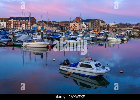 Weymouth harbour tramonto sul fiume Wey barche e sul lato del porto case colorate e pub, Weymouth Dorset,,l'Inghilterra,uk,GB Foto Stock