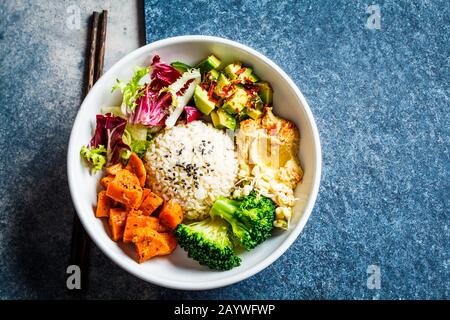 Ciotola di Buddha. Insalata di riso e verdure vegane. Set macrobiotico con riso, hummus, avocado, broccoli e patate dolci. Foto Stock