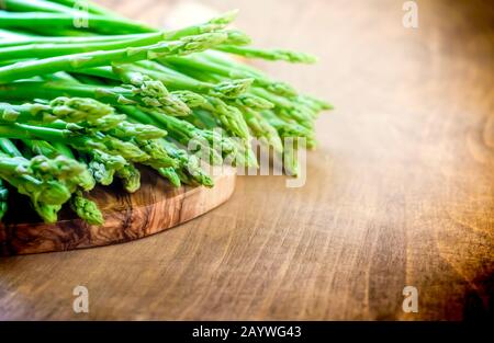 asparagi freschi adagiati su una tavola da cucina in legno Foto Stock