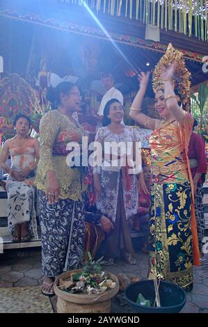 Una sposa Balinese e' guidata attraverso una tradizionale cerimonia da altre donne Balinesi. Foto Stock