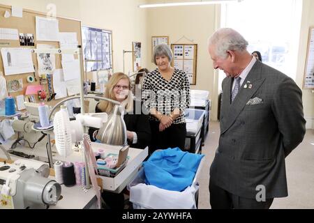 Il Principe del Galles parla con i dipendenti durante la sua visita alla fabbrica di magliette su misura Emma Willis Ltd a Gloucester. Foto Stock