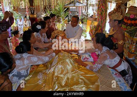 Una donna Balinese è guidata attraverso un rituale dei denti di taglio. Il taglio dei denti e' un tradizionale rituale Balinese come segno della maturità di una donna Balinese. Foto Stock