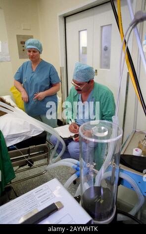 Anestesista che monitora i segni vitali dei pazienti durante l'intervento chirurgico Foto Stock