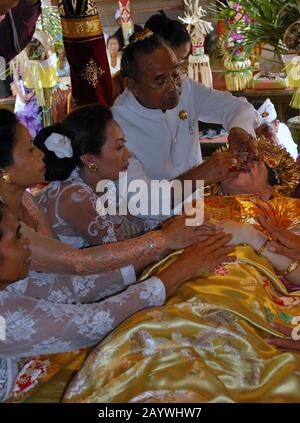 Una donna Balinese è guidata attraverso un rituale dei denti di taglio. Il taglio dei denti e' un tradizionale rituale Balinese come segno della maturità di una donna Balinese. Foto Stock