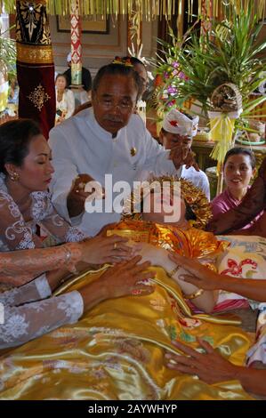 Una donna Balinese è guidata attraverso un rituale dei denti di taglio. Il taglio dei denti e' un tradizionale rituale Balinese come segno della maturità di una donna Balinese. Foto Stock