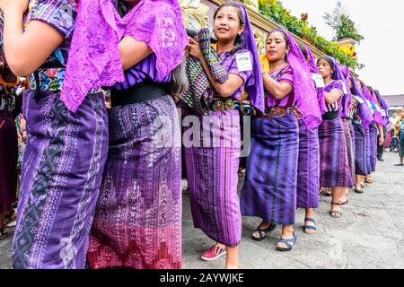 Santiago Atitlan, Guatemala - 19 aprile 2019: Donne Maya vestite con abiti tradizionali portano Il buon venerdì processione galleggiante nella città del lago Atitlan. Foto Stock