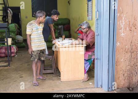 Dambulla, Sri Lanka: 18/03/2019: All'interno del mercato della vendita di whoelsale di frutta e verdura. Uomini negociating prezzi per i prodotti. Foto Stock