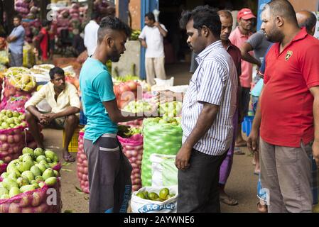 Dambulla, Sri Lanka: 18/03/2019: All'interno del mercato della vendita di whoelsale di frutta e verdura. Uomini che negoziano i prezzi per i prodotti. Foto Stock