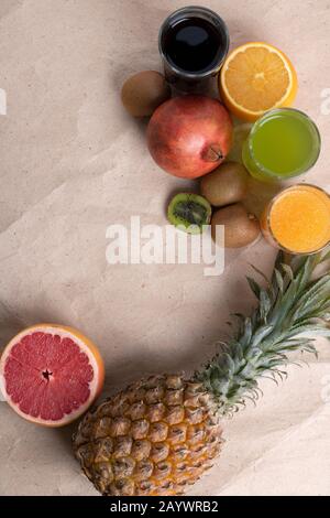 Frutti esotici su sfondo grigio. Frutti tropicali fissati su carta ecologica, zero sprechi Foto Stock