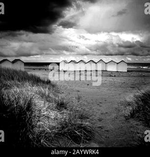 OUISTREHAM. Cabine sulla spiaggia, sotto un cielo tempestoso in Normandia, Calvados, Francia Foto Stock