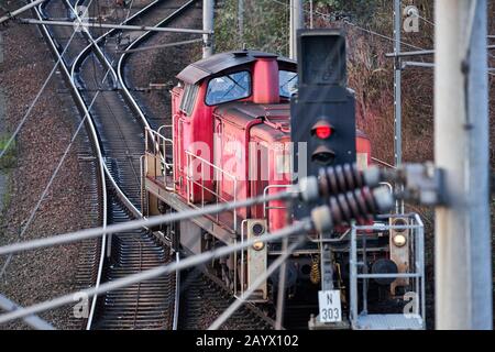 Wolfsburg, Germania, 10 gennaio 2020: Locomotiva rossa per carri merci davanti a un segnale di stop Foto Stock