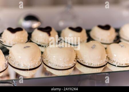 candy bar. Torta mousse alla moda con glassa a specchio bianco e chokolate con scaglie di cocco. Dessert moderno Foto Stock