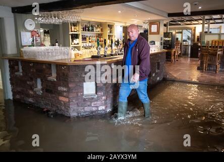 Il Locatore Colin Reynolds cammina attraverso l'acqua alluvionale nella locanda delle navi di Acaster Malbis, vicino York, dopo la tempesta Dennis. Foto Stock