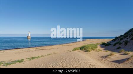 Rattray Point Beach con il suo faro appena fuori Dalla Costa sulla costa orientale della Scozia in Aberdeenshire Foto Stock