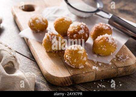 Frittelle di Carnevale o buñuelos de viento per la settimana Santa su tavola di legno Foto Stock